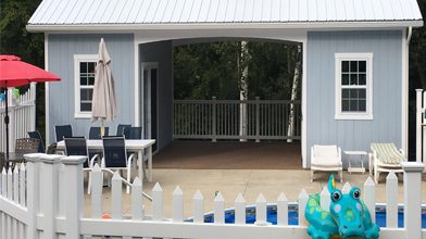 custom pool house with fence in front